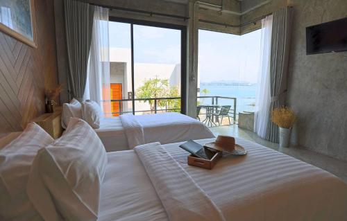 a bedroom with two beds with a view of the ocean at De' Anchor in Ko Si Chang