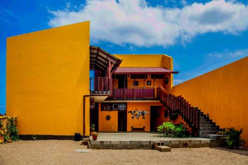 um edifício amarelo com uma escada em frente em Museu Mafalala B&B em Maputo