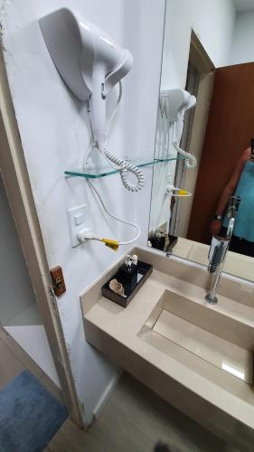 a bathroom with a sink and a mirror at #01 Boulevard Amazon Suites in Manaus
