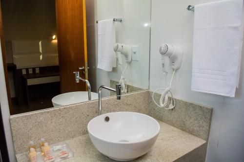 a bathroom with a white sink and a mirror at POUSADA ESTÂNCIA in Penedo