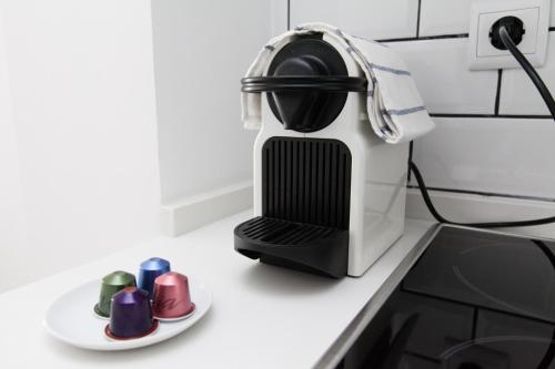 a coffee maker on a counter next to a plate of cups at GoToSeville Molviedro Apartments in Seville