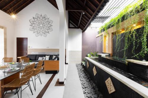 a dining room and living room with a table and chairs at Villa Lapiz Lazuli Seminyak Kuta in Seminyak