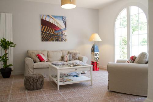 a living room with a couch and a table at Hôtel Le Vert Bois in Dolus d'Oléron