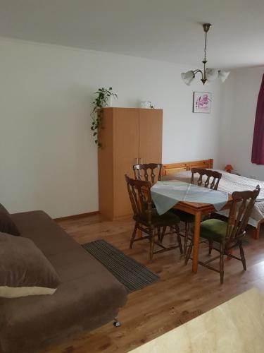 a living room with a couch and a table and chairs at Boróka Vendégház in Aggtelek