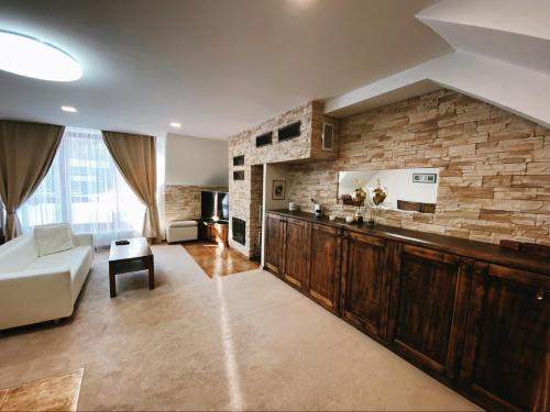 a living room with a couch and a stone wall at Apartmán de luxe s výhľadom na Lomnický štít in Tatranská Lomnica