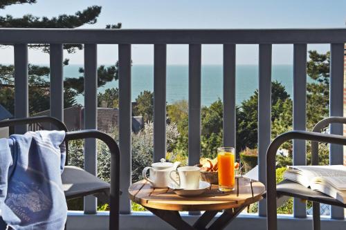 een tafel met twee kopjes koffie op een balkon bij Hotel Le Bellevue, Demeures & Chateaux in Villerville