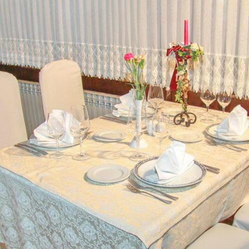 a table with plates and glasses and a red candle at Hotel Villa Neretva - Metković in Metković