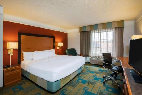 ein Hotelzimmer mit einem großen Bett und einem Schreibtisch in der Unterkunft La Quinta by Wyndham Colorado Springs South Airport in Colorado Springs
