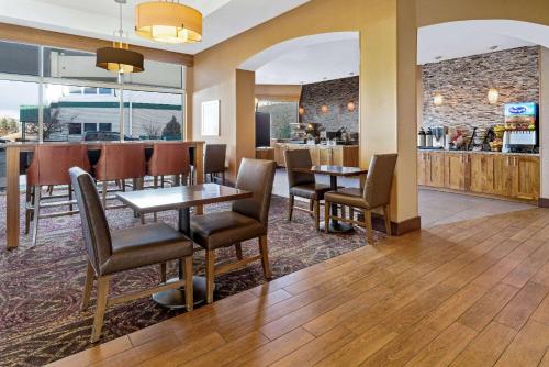 a restaurant with tables and chairs and a bar at La Quinta by Wyndham Butte in Butte
