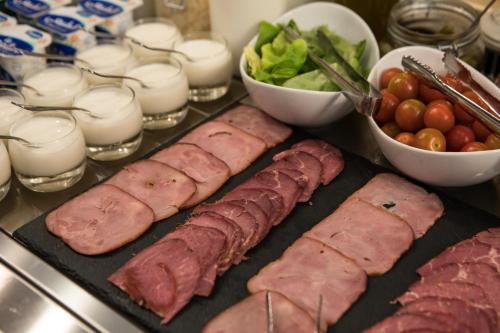 a table with meat and vegetables and glasses of milk at Ibis Abdelmoumen Casa Centre in Casablanca
