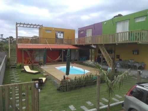 a house with a pool and a deck with a playground at Morada Betel Box in Praia do Rosa