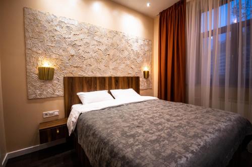 a bedroom with a bed and a painting on the wall at Kyiv Panorama Apartments near Gulliver in Kyiv