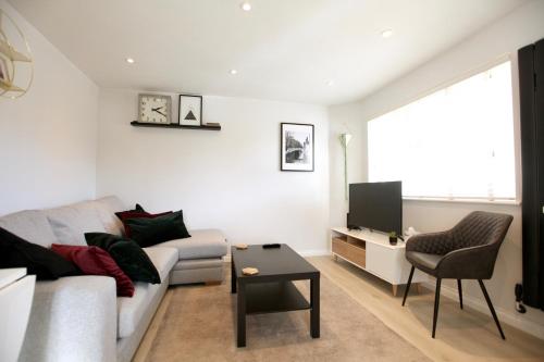 a living room with a couch and a tv at Stylish Cambridge Pad in Bar Hill