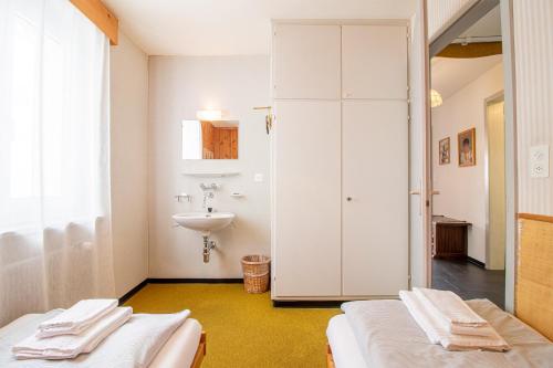 een badkamer met 2 bedden en een wastafel bij Viktoria B32 by Arosa Holiday in Arosa