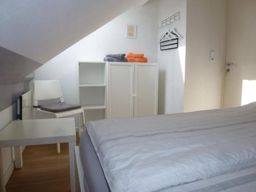 a bedroom with a bed and a table and a desk at Ferienwohnung Am Runenstein 7 in Busdorf