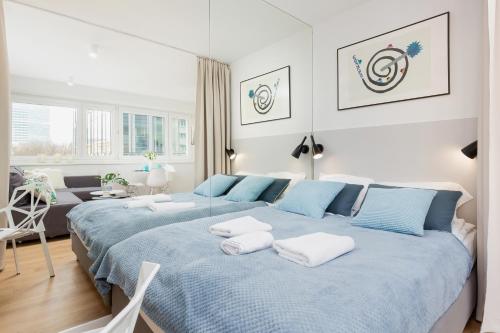 a bedroom with two beds and a living room at Deluxe Studio Warsaw City Center by Renters in Warsaw