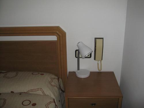 a bedroom with a bed and a lamp on a nightstand at Hostal Fontdemora in Móra la Nova