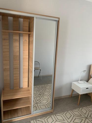 a mirror in a room with a table and a chair at Good Rest in Chemerivtsi