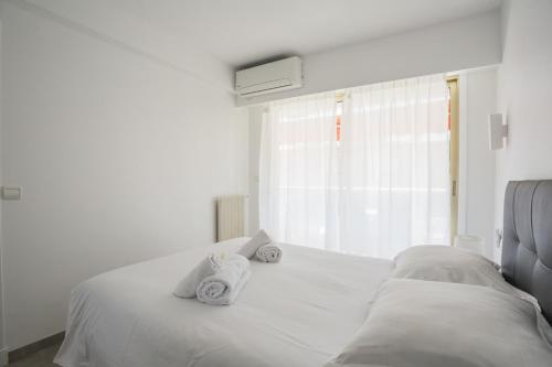 a white bed with towels on it with a window at Bright One BDRM Apartment AC-Congress, Beaches by Olidesi in Cannes
