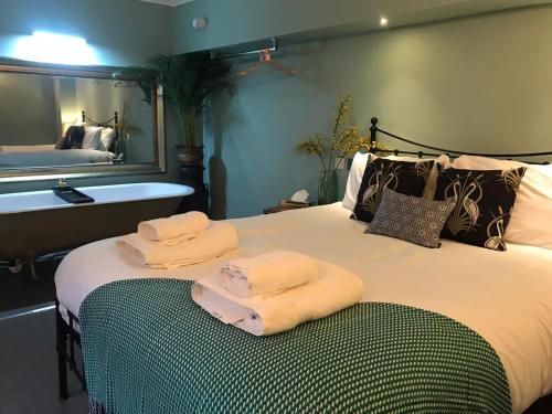 a bedroom with a large bed with towels on it at Haweswater Hotel in Bampton