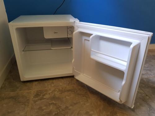 an empty white refrigerator with its door open at Recanto do Luar in São Miguel do Gostoso
