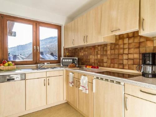 a kitchen with wooden cabinets and a sink and a window at Schwarzwaldmädel-Ferienwohnungen in Todtnau