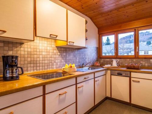 a kitchen with white cabinets and a sink at Schwarzwaldmädel-Ferienwohnungen in Todtnau