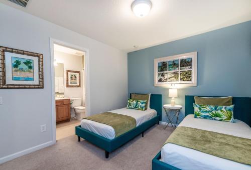 a bedroom with two beds and a bathroom at Spacious Home wPrivate PoolSpa & FREE Waterpark in Orlando
