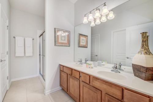 a white bathroom with a sink and a shower at Spacious Home wPrivate PoolSpa & FREE Waterpark in Orlando