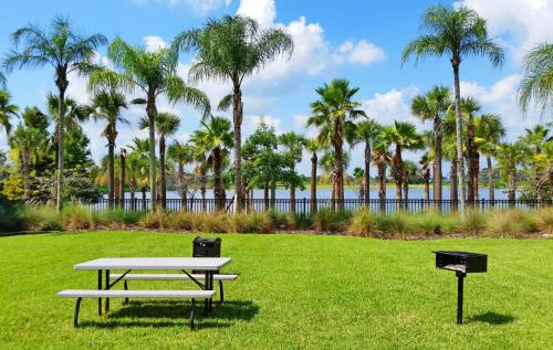 a picnic table in a park with palm trees at Cozy Condo wPrivate Balcony & FREE Resort Access in Orlando
