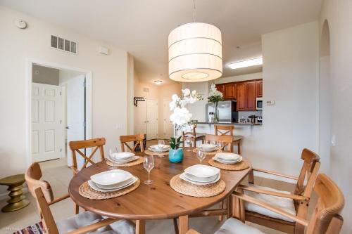 a dining room and kitchen with a wooden table and chairs at Cozy Condo wPrivate Balcony & FREE Resort Access in Orlando