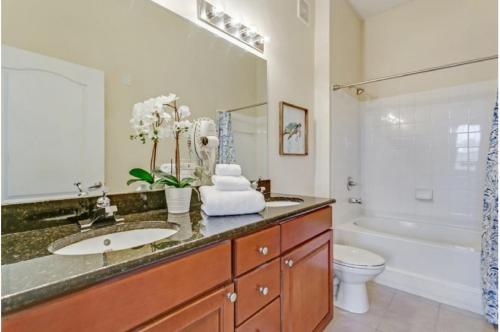 a bathroom with a sink and a tub and a toilet at Two-Bedroom Apartment Davenport in Davenport