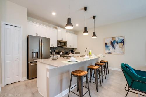 a kitchen with a large island with bar stools at 4814 Lullaby Lane in Kissimmee