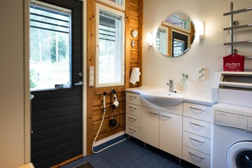 een badkamer met een wastafel en een spiegel bij Leena's B&B in Inkoo