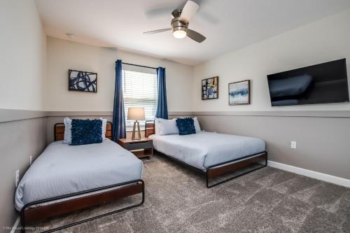 Un dormitorio con dos camas y un televisor de pantalla plana. en 4814 Lullaby Lane, en Kissimmee