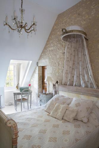 une chambre avec un lit avec un mur en pierre dans l'établissement Manoir de la Foulquetiere, à Luçay-le-Mâle