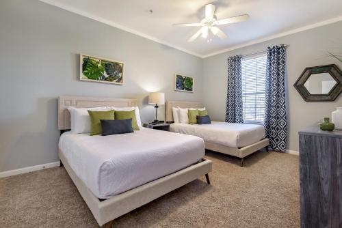 a bedroom with two beds and a ceiling fan at Beautiful Vista Cay Condo, Near I-Drive in Orlando