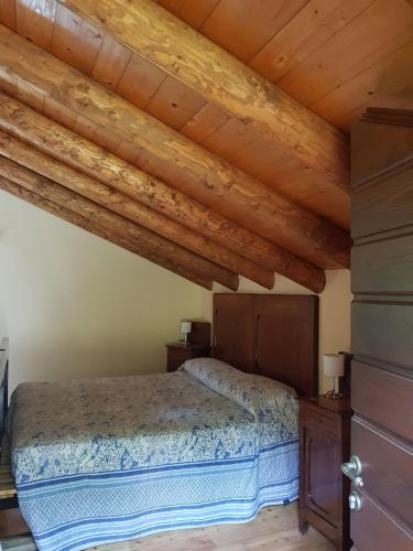 a bedroom with a bed and wooden ceilings at Baita Eleonora in Argegno