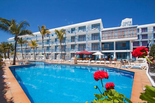 a hotel with a swimming pool in front of a building at Aparthotel Costa Volcán & Spa in Puerto del Carmen