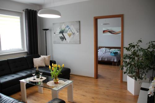 a living room with a black couch and a table at Apartament Ania in Jelenia Góra
