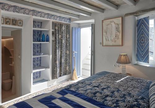 a blue and white bedroom with a bed and a window at Xinara House in Tripótamos