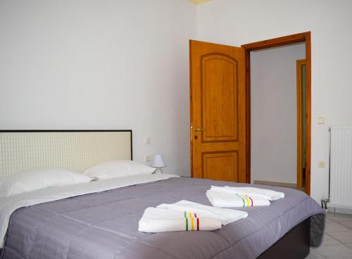 1 dormitorio con 1 cama con toallas en Pine tree house en Troulos
