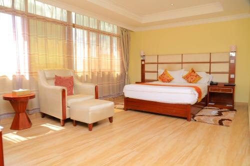 a bedroom with a bed and a chair at Tiffany Diamond Hotels Ltd - Indira Gandhi street in Dar es Salaam