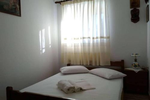 a bedroom with a bed with two pillows and a window at Kasi's nature home in Kythira