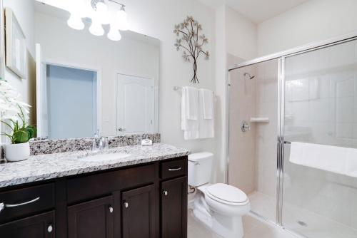 een badkamer met een toilet, een wastafel en een douche bij Pool Villa wFREE Waterpark Lazy River Game Room in Kissimmee