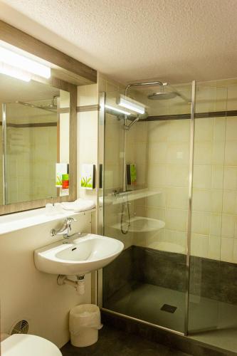 a bathroom with a sink and a shower at initial by balladins La Roche-sur-Yon in La Roche-sur-Yon