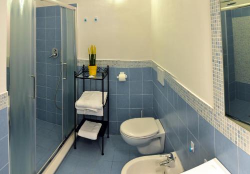 e bagno piastrellato blu con servizi igienici e doccia. di Hotel Casa Rosa Terme a Ischia