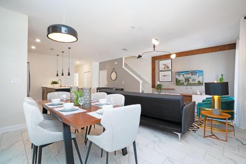 a dining room and living room with a table and chairs at Beautiful Modern Home wPrivate Pool Near WDW in Kissimmee