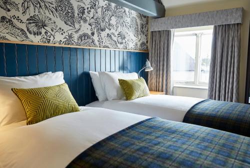 a hotel room with two beds and a window at Pen and Parchment by Greene King Inns in Stratford-upon-Avon