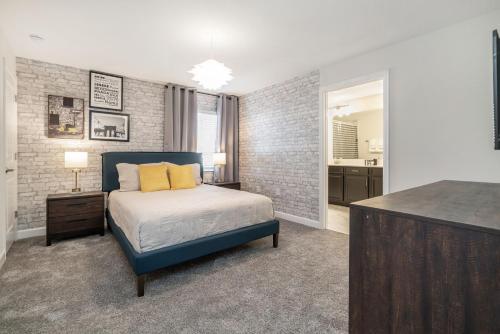 a bedroom with a bed with yellow pillows on it at Beautiful Modern Home wPrivate Pool Near WDW in Kissimmee